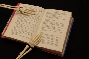 A skeleton reading a book.
