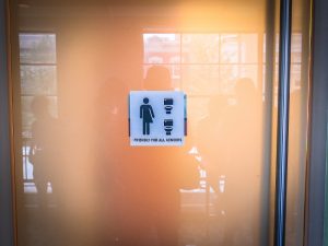 A bathroom sign welcoming all genders.