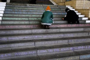 Students writing out the universal declaration of human rights in chalk.