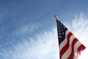 A US flag hanging limply on a still day.