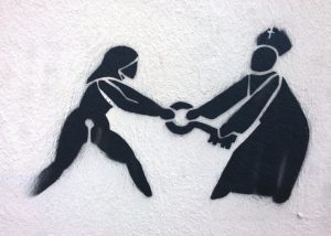 Pro-choice graffiti showing a person wrestling with a priest for control of a key.