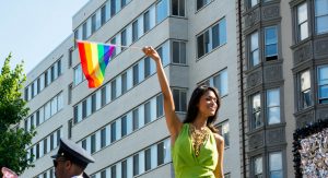 A Latina waving a pride flag.