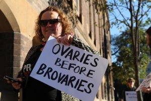 A person holding up an ovaries before brovaries sign.