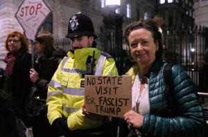 A woman holding up a sign calling for no state visit for Donald Trump.