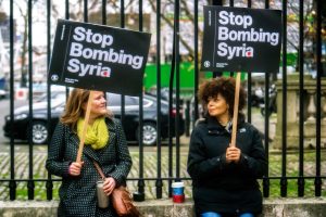 Two people holding anti-war signs.