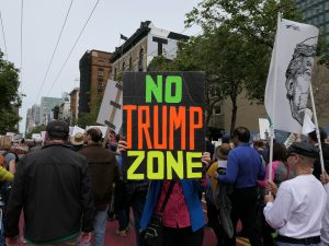 Protesters holding up a NO TRUMP ZONE sign