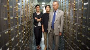 A still from the documentary Abacus showing three Chinese-Americans standing in a bank vault