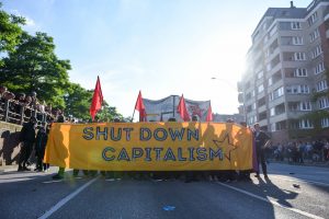 G20 protesters carrying a SHUT DOWN CAPITALISM sign