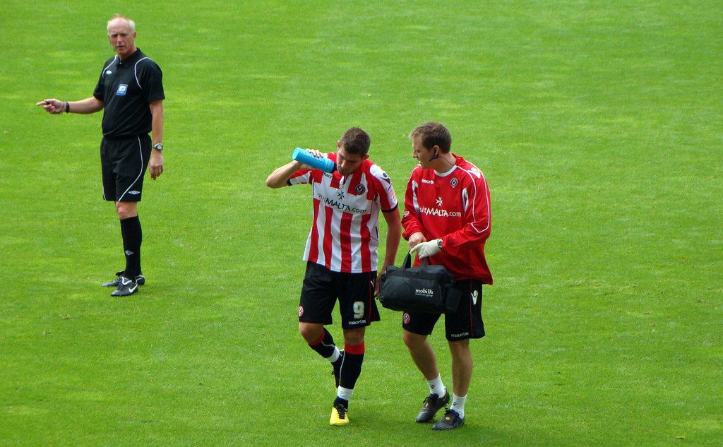 Footballer Ched Evans talking to a field official.