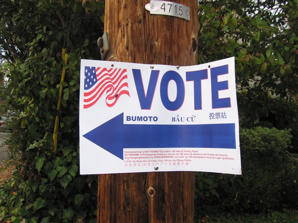 A sign pointing towards a polling place.