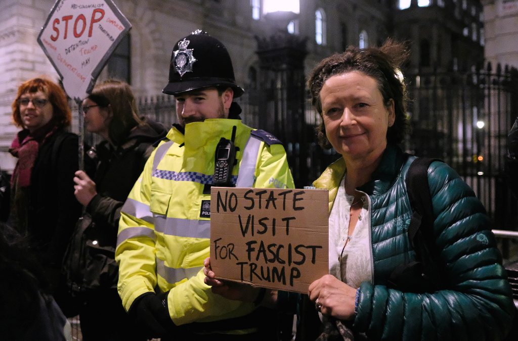 A woman holding up a sign calling for no state visit for Donald Trump.