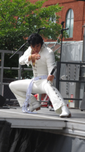 an elvis impersonator doing a knee slide